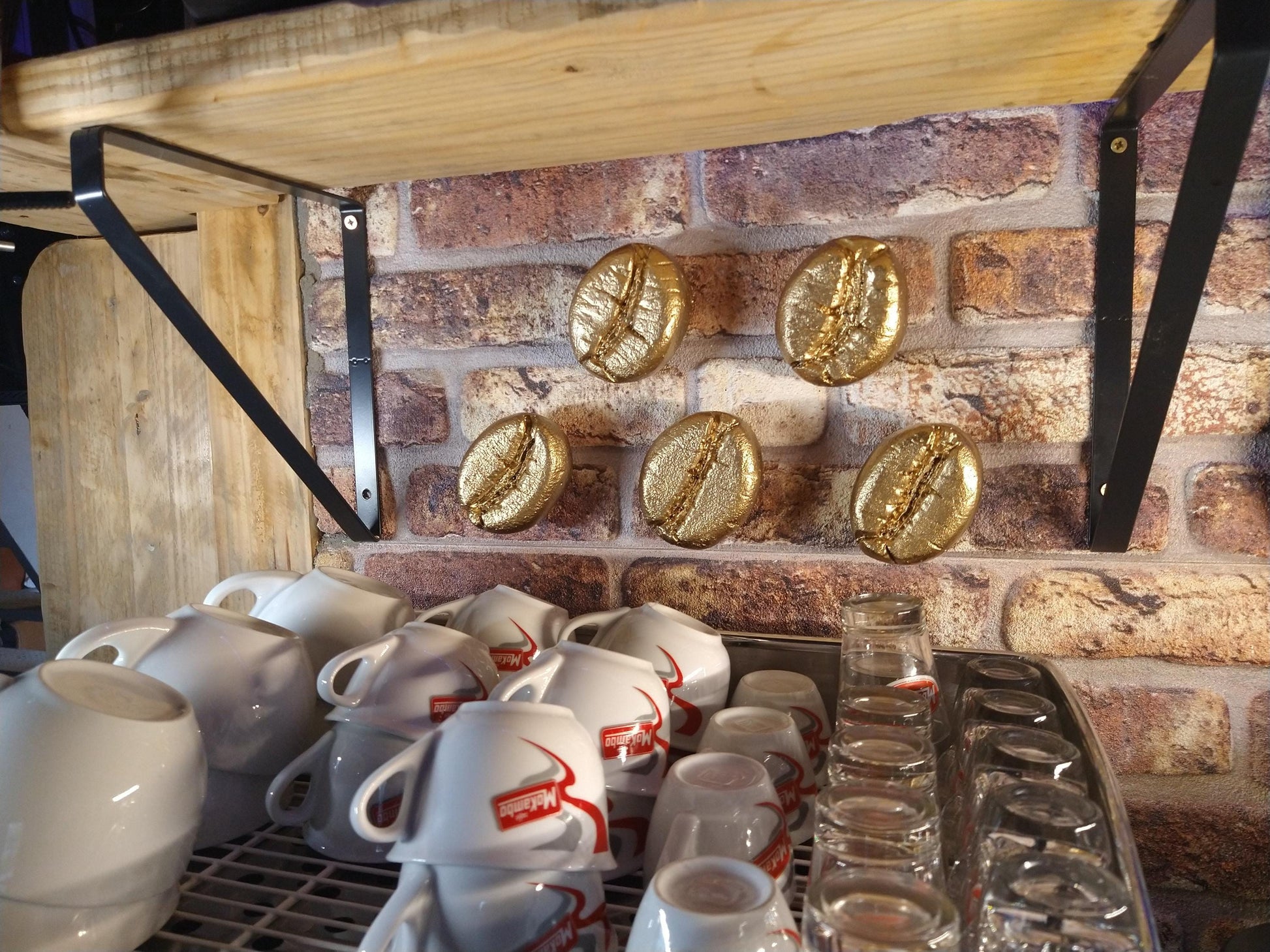 gouden koffieboon sculpturen boven koffieapparaat 