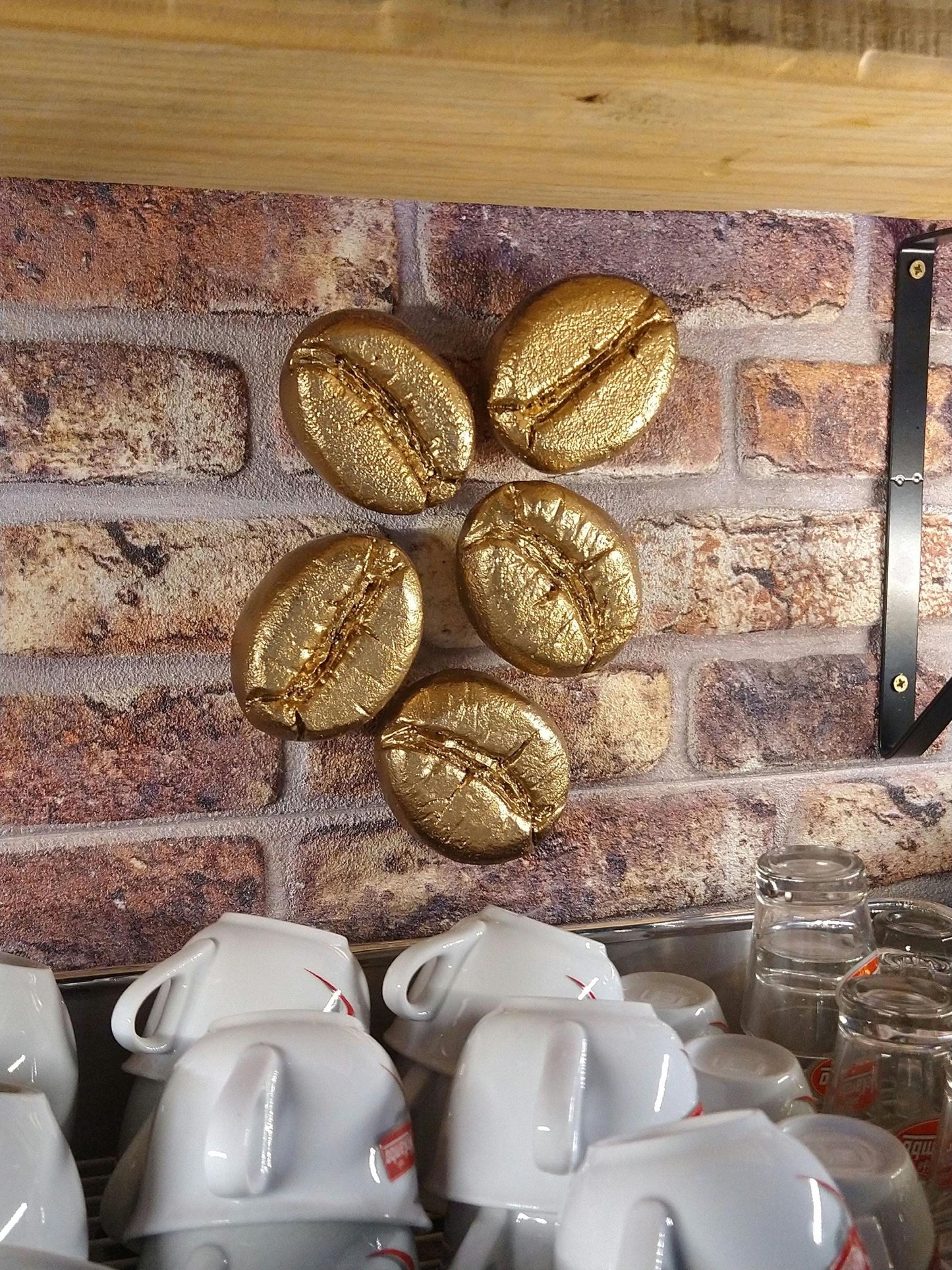 gouden koffieboon sculpturen boven koffieapparaat 